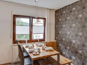 a dining room with a wooden table and a window at Pretty apartment in Medebach with adjacent forest in Medebach