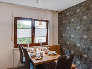 a dining room with a table and chairs and a window at Pretty apartment in Medebach with adjacent forest in Medebach