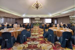 uma sala de conferências com mesas e cadeiras e um lustre em Four Star by Trans Hotel em Sanur