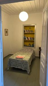 a bedroom with a bed in a room with a book shelf at Traditional Detached House in Spetses