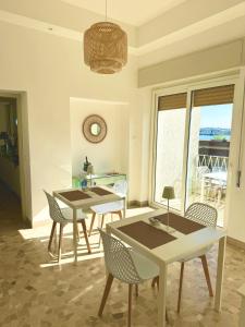 un comedor con mesas y sillas y una ventana en Villa Magnolia, en Formia