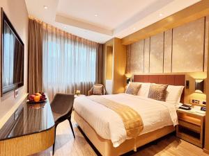 Habitación de hotel con cama y escritorio en Grand Dragon Hotel, en Macau