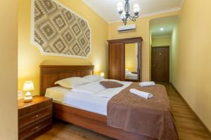 a bedroom with a bed with white sheets and a mirror at Hotel Middleton in Tbilisi City
