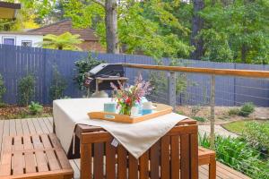 a table on a deck with a bbq grill at Nature Lovers Dream - Hikes & Fireplace in Wentworth Falls