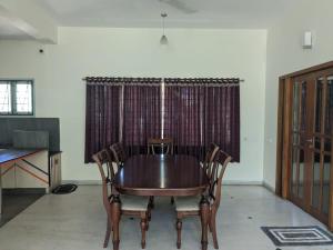 a dining room with a wooden table and chairs at Shanthi Nivaas in Chennai