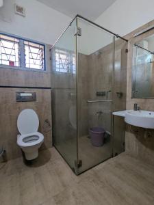 a bathroom with a shower and a toilet and a sink at Shanthi Nivaas in Chennai