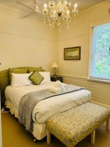 a bedroom with a large bed and a chandelier at Elevated Serenity - Where Views Meet Comfort in Katoomba