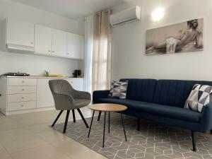 un soggiorno con divano blu e tavolo di Deda Apartments a Livadia