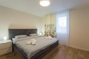 een slaapkamer met een groot bed met 2 witte kussens bij Hermann Central Apartment in Sibiu