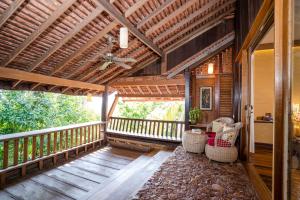 a porch of a house with chairs and a ceiling at Veranda Natural Resort in Kep
