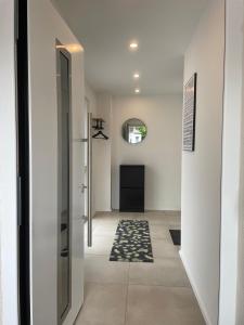 a hallway with white walls and a door with a rug at City Wohnung mit Gartenblick und Dachterrasse in Verden