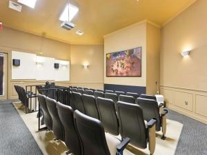 uma sala de conferências com cadeiras pretas e um quadro na parede em Archfeld Villa 2582 em Orlando