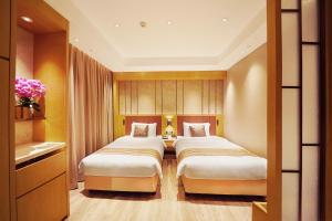 2 camas en una habitación de hotel con en Grand Dragon Hotel, en Macau