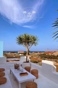 a table and chairs on a balcony with a palm tree at Lo Villa - Venuestay in Phu Yen