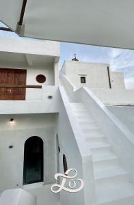 a white house with a staircase with a scissors sign on it at Lo Villa - Venuestay in Phu Yen