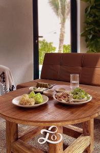 a wooden table with two plates of food on it at Lo Villa - Venuestay in Phu Yen