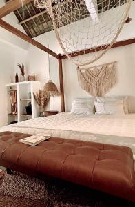 ein Schlafzimmer mit einer Hängematte, die über einem Bett hängt in der Unterkunft Lo Villa - Venuestay in Phu Yen