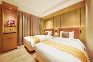 una habitación de hotel con 2 camas en una habitación en Grand Dragon Hotel, en Macau