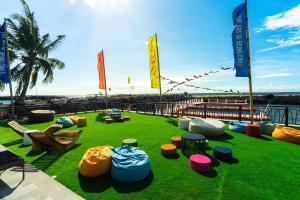 a field of grass with colorful chairs and flags at UNWND Boutique Hotel Camiguin in Mambajao