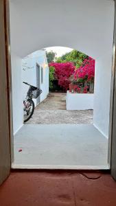 Blick auf ein Motorrad durch eine offene Tür in der Unterkunft Traditional Detached House in Spetses