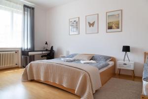 a white bedroom with a bed and a desk at Feel Like Home @Strakova, Very central luxury APT in Bratislava