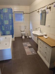 克魯姆赫爾恩的住宿－Gulfhof Anelis，浴室配有盥洗盆、卫生间和浴缸。