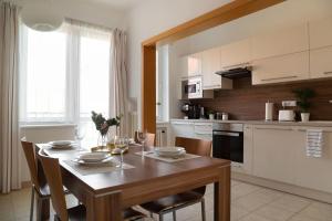a kitchen with a wooden table with chairs and a dining room at Feel Like Home @Strakova, Very central luxury APT in Bratislava