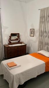 a bedroom with a bed and a dresser and a mirror at Traditional Detached House in Spetses