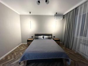 1 dormitorio con 1 cama grande en una habitación en 1-комнатная квартира, 43.7 м², 8/9 этаж посуточно en Zhumysker