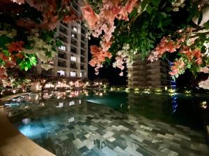uma piscina de água com flores e luzes rosa em Gold Coast Apartments em Nha Trang