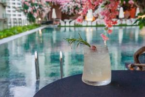 uma bebida sentada numa mesa ao lado de uma piscina em Gold Coast Apartments em Nha Trang