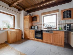 a kitchen with wooden cabinets and a stove top oven at Beautiful holiday home in Viechtach with views in Viechtach