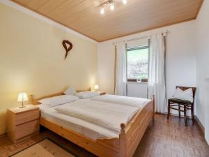 ヴィヒタッハにあるBeautiful holiday home in Viechtach with viewsのベッドルーム1室(ベッド1台、窓、椅子付)