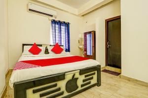 1 dormitorio con 1 cama grande con almohadas rojas en OYO ROYAL HAVEN, en Hyderabad