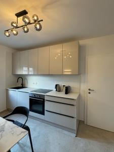 a kitchen with white cabinets and a table with a chair at Sugar house in Pag