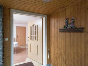 an open door in a room with wooden walls at Holiday homes for two people with a swimming pool in the Ore Mountains in Pockau