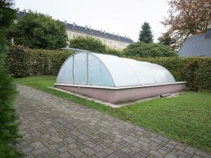 a greenhouse sitting on the grass in a yard at Holiday homes for two people with a swimming pool in the Ore Mountains in Pockau