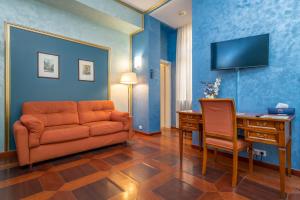 a living room with an orange couch and a desk at Hotel Kinsky Fountain in Prague