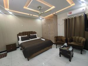 a bedroom with a bed and a couch and a chair at Airwaylodges in Islamabad