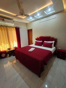 a bedroom with a large bed with red sheets at Airwaylodges in Islamabad
