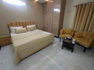 a bedroom with a large bed and a chair at Airwaylodges in Islamabad