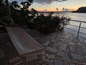 a hammock sitting on a patio next to the water at Apartman Bačarije,Pag-Prizna in Seline