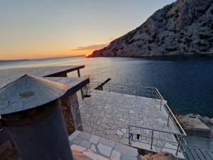 un barco en el agua con la puesta de sol en el fondo en Apartman Bačarije,Pag-Prizna en Seline