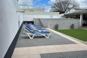 - une rangée de chaises longues bleues sur la terrasse dans l'établissement Casa dos Avós no Grande Lago, à Granja