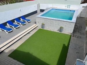 - une vue sur la piscine entourée de chaises et d'une pelouse verdoyante dans l'établissement Casa dos Avós no Grande Lago, à Granja