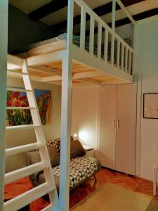 una stanza con un letto a soppalco con un divano sotto di Isola Studio Rosa a Izola