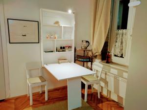 un tavolo bianco e sedie in una stanza di Isola Studio Rosa a Izola