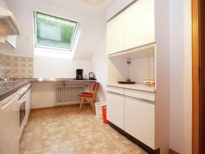 eine kleine Küche mit weißen Schränken und einem Fenster in der Unterkunft Modern Apartment in Bad Peterstal Griesbach with Vineyards in Bad Peterstal