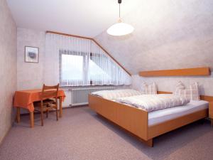 Schlafzimmer mit einem Bett, einem Schreibtisch und einem Tisch in der Unterkunft Modern Apartment in Bad Peterstal Griesbach with Vineyards in Bad Peterstal