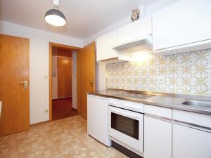 una cocina con armarios blancos y fregadero en Modern Apartment in Bad Peterstal Griesbach with Vineyards, en Bad Peterstal